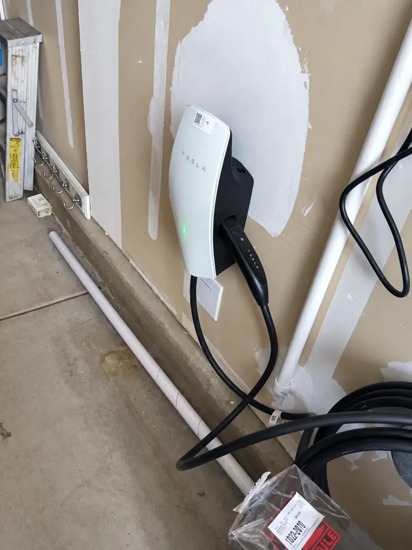 Tesla charger installed in a garage under construction